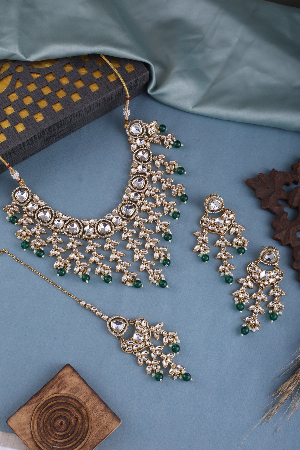 Emerald Green Kundan Cascade Necklace Set with Maang Tikka, styled flat lay