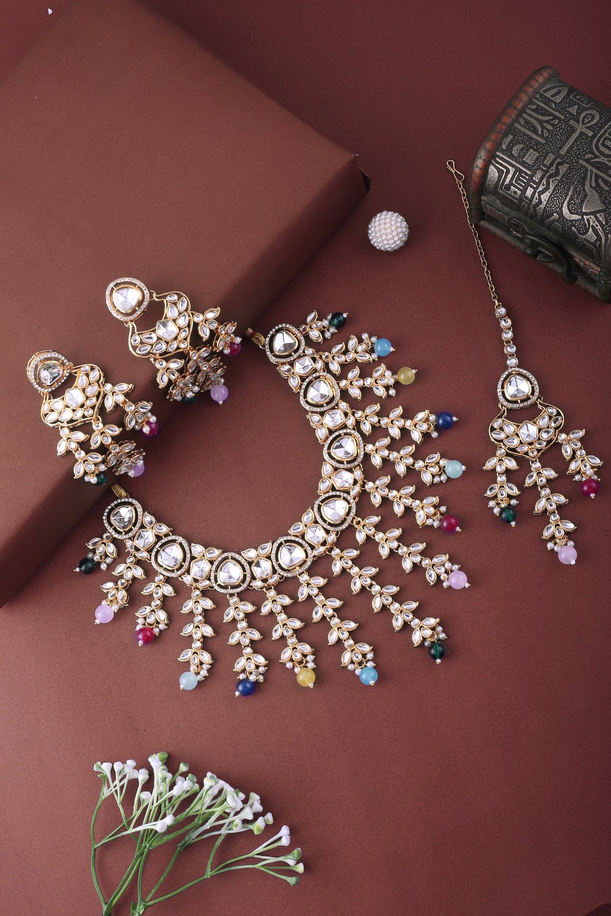 Multicolor Kundan Cascade Necklace Set with Maang Tikka, styled flat lay
