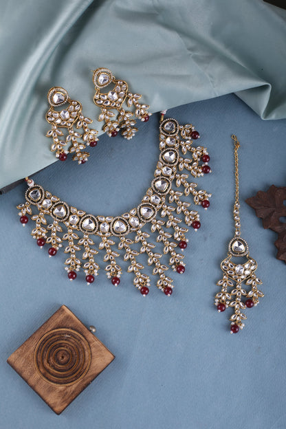 Ruby Red Kundan Cascade Necklace Set with Maang Tikka, styled flat lay