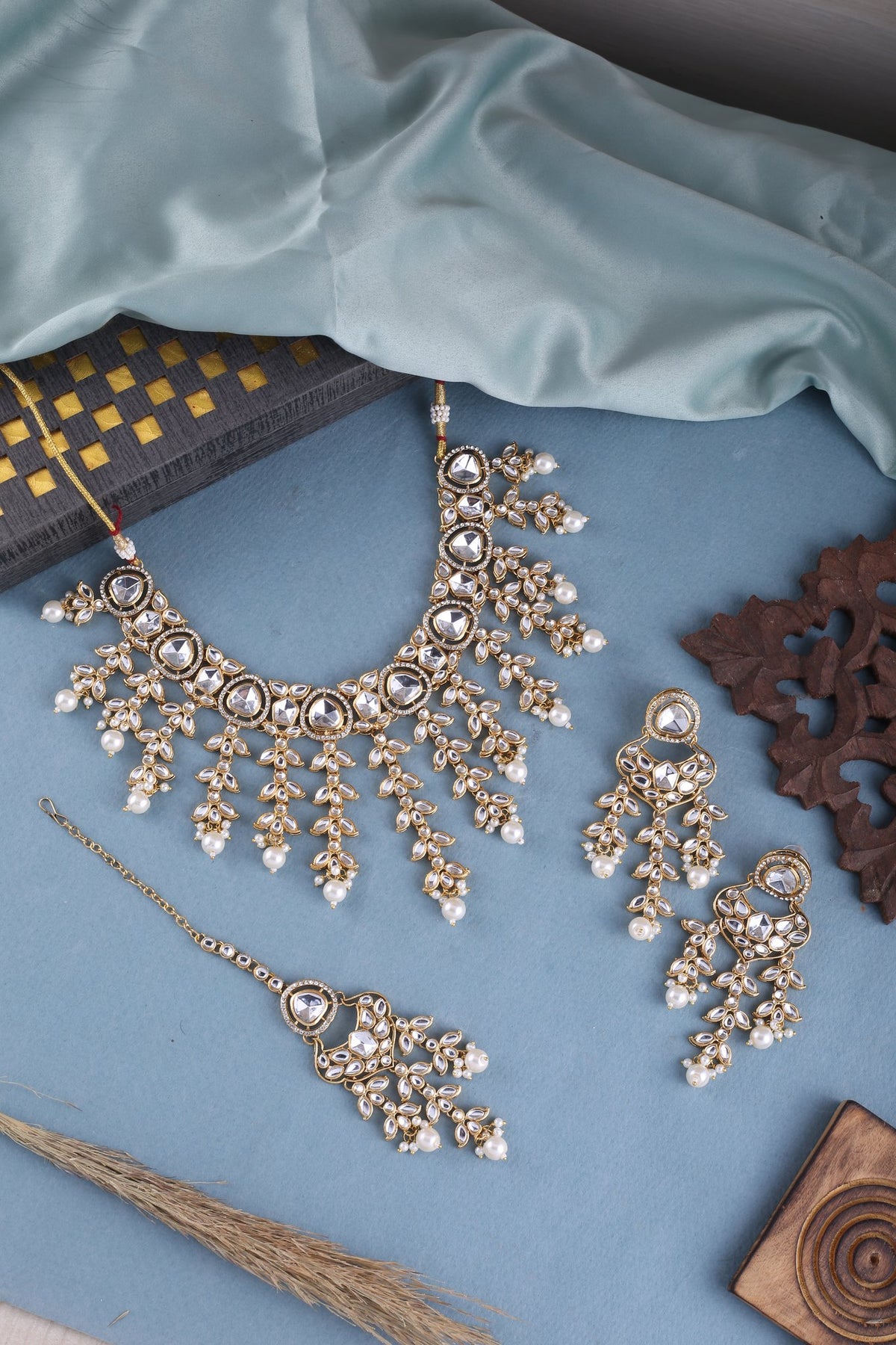 Pearl Kundan Cascade Necklace Set with Maang Tikka, styled flat lay