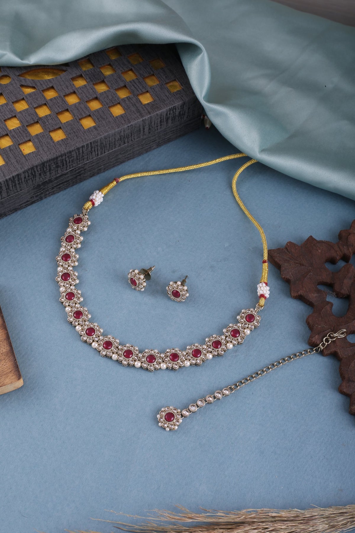 Ruby Red Polki Floral Necklace Set with Studs &amp; Maang Tikka, styled flat lay