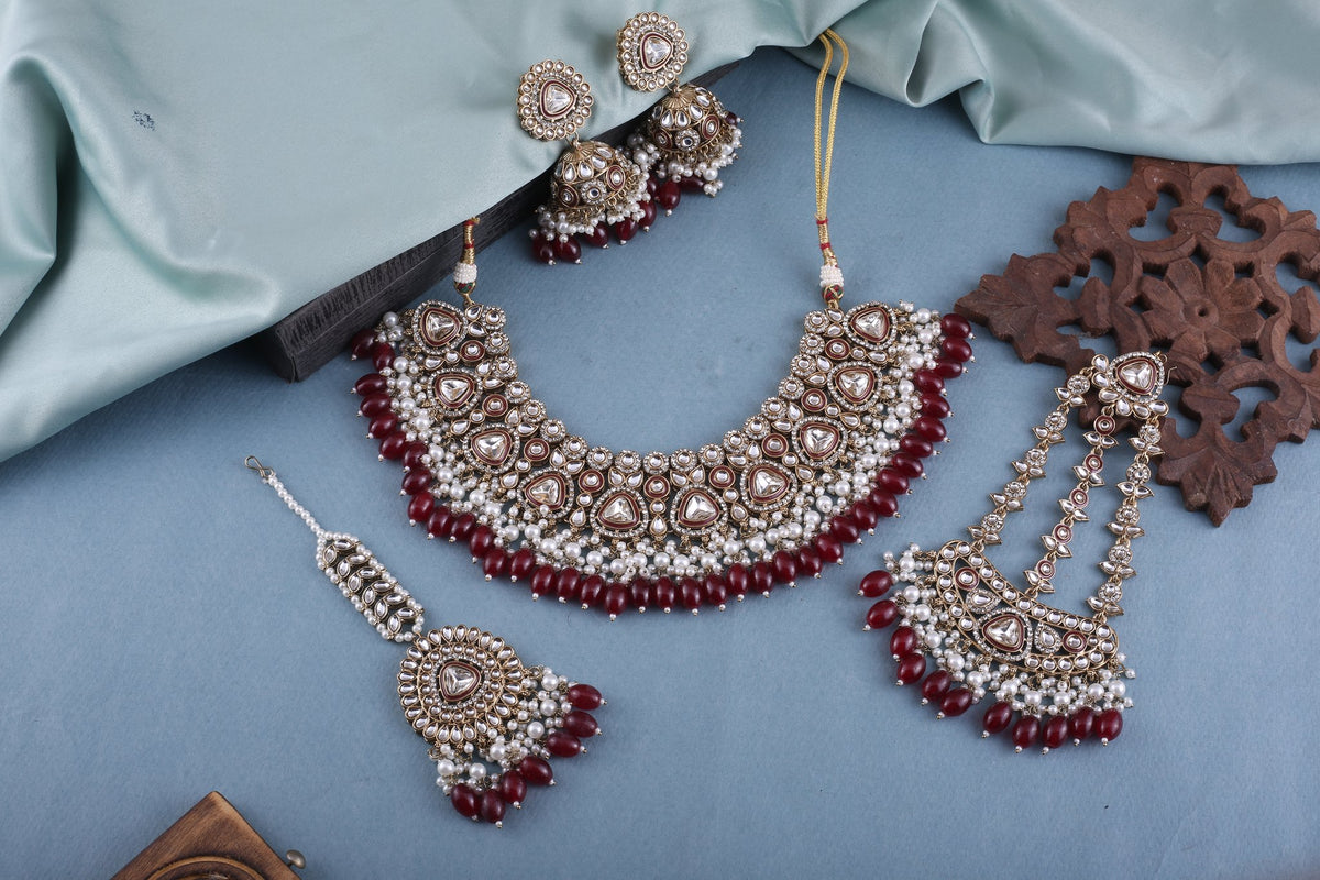 Ruby Polki Bridal Choker Set with Jhumkas, Maang Tikka &amp; Passa, styled flat lay