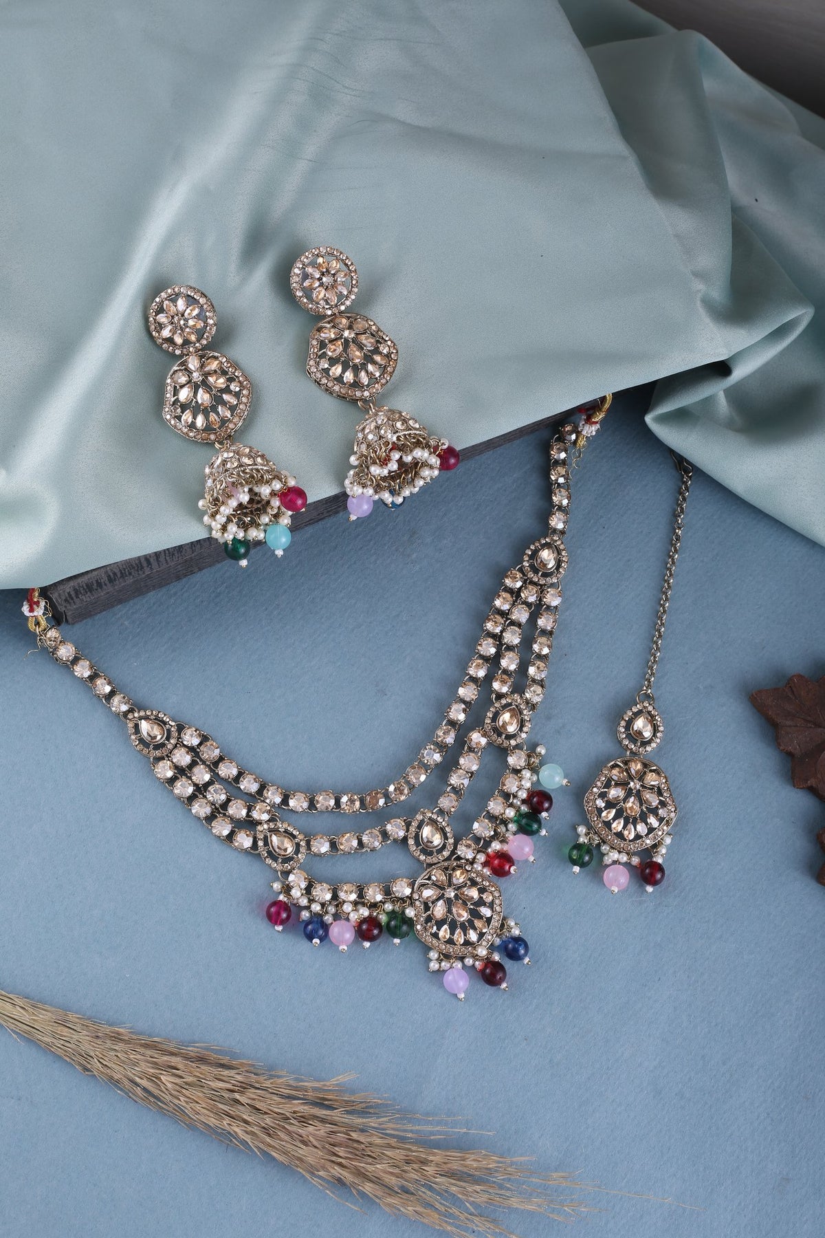 Multicolor Three Layer Polki Necklace Set with Jhumkas &amp; Maang Tikka, styled flat lay